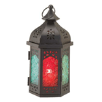 The alluring hues of a Moroccan night shine from the richly colored patterned glass of this magnificent candle lantern. Dark metal accented with decorative cutouts holds the exotic glass of this tabletop lantern, and when you place the candle of your choice inside and light the wick you’ll enjoy its lively ambiance. 