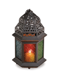 The graceful cutouts in this candle lantern’s shell throw dancing laceworks of light, while patterned multi-colored glass panels cast a halo of color. Suitable for hanging, or use as a free-standing lamp.