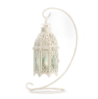 The glow of a tealight through the pale green glass panes and the charming lattice-designed cutouts of the shell add a romantic aura to any setting. Hang the lantern on the accompanying stand for heightened effect!