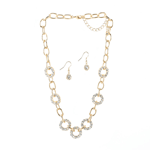 Golden links and dazzling crystalline gems link together in a flurry of style to create this luxe necklace. This beautiful jewelry set features matching drop earrings inset with sparkling stones.