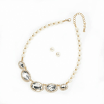 Radiant oval stones and faux pearls combine to create a simply stunning jewelry set that will complement any outfit in your closet. The adjustable-length necklace features pearlescent and golden beads and large clear stones surrounded by smaller gems, while the earrings are simple and classic. 